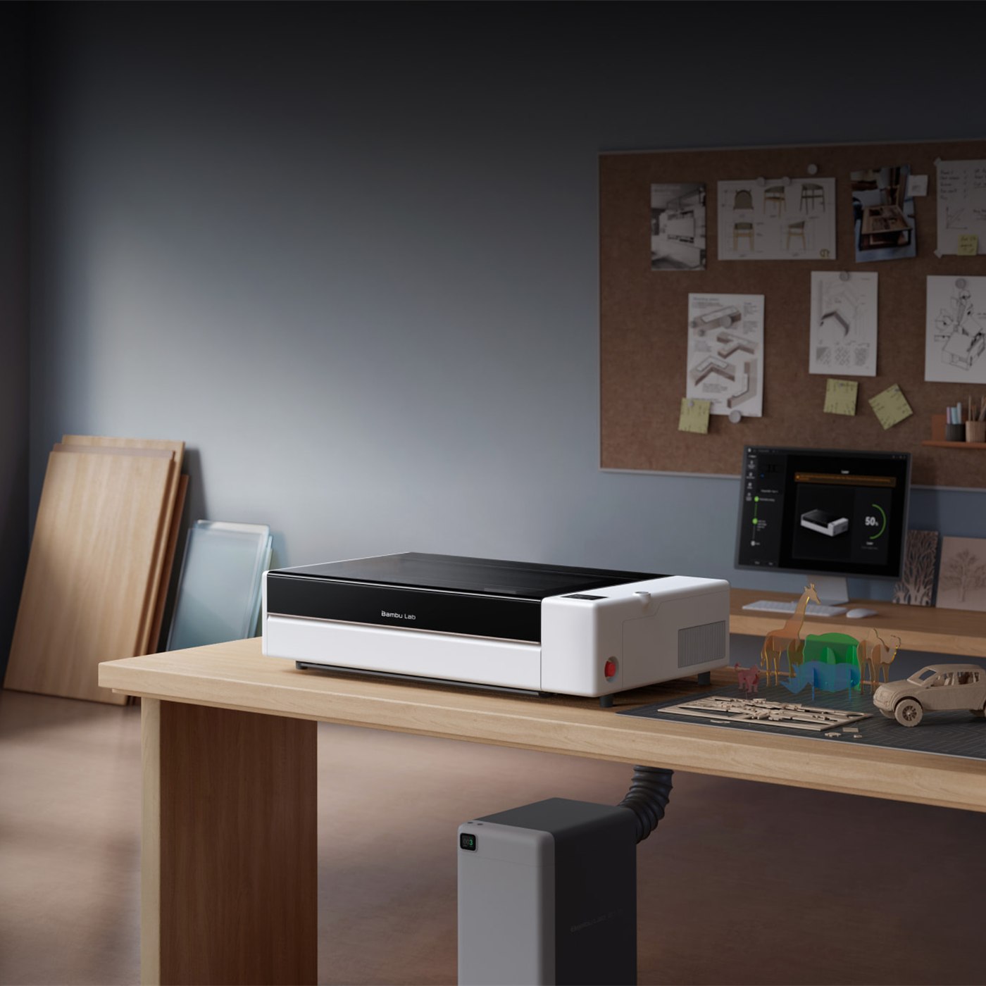 Bambu Lab R1 set up on a studio desk with materials and laser-cut pieces